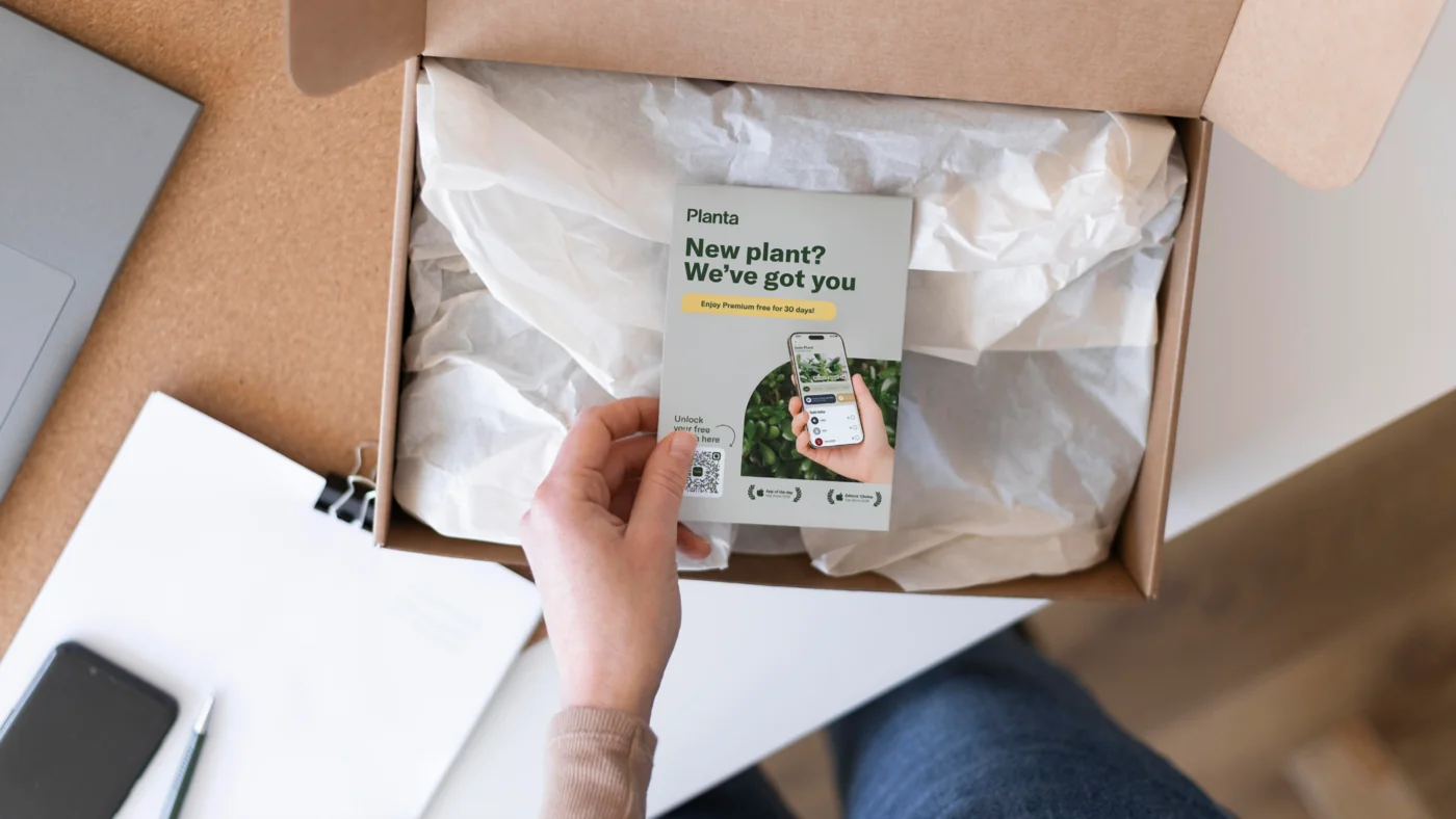 Hand holding a Planta insert card inside a shipped box